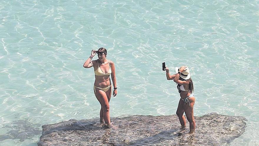 Dos bañistas se hacen selfies en Caló des Moro