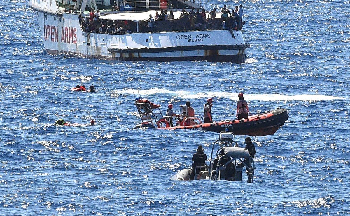 Migrants swim after jumping off the Spanish rescue ship Open Arms, close to the Italian shore in Lampedusa, Italy August 20, 2019. REUTERS/Guglielmo Mangiapane