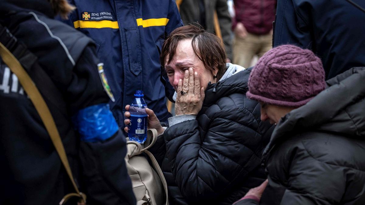 Una mujer reacciona mientras es asistida por la policía tras huir de su casa en los suburbios de Kiev, el 26 de marzo de 2022.