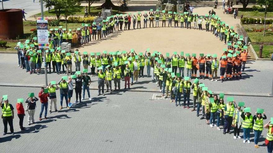 Los trabajadores de Ence iniciaron la protesta formando un lazo verde, símbolo de su lucha, ante el Concello de Pontevedra. // Rafa Vázquez