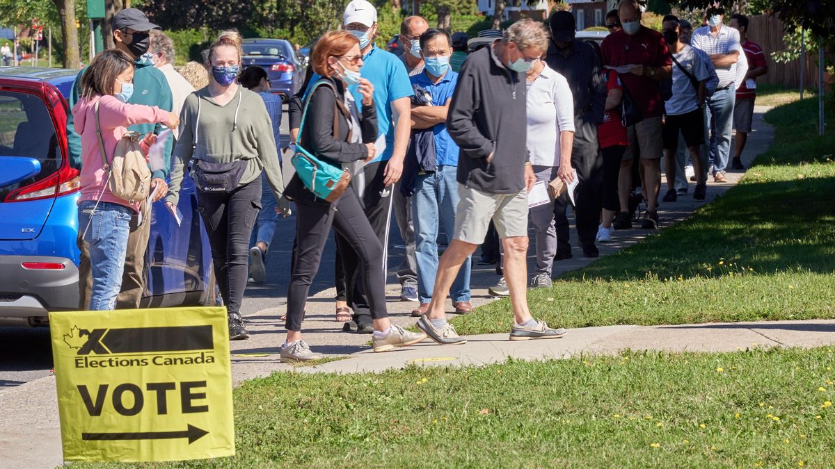 A line of people waits to cast their vote in Canada. A line of people waits to cast their vote in Canada.