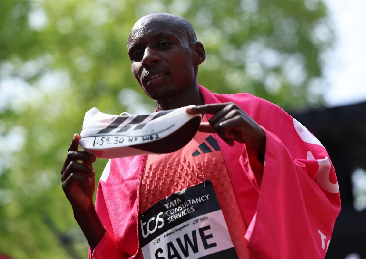El atleta keniano Sabastian Sawe posa con su zapatilla, tras ganar el maratón de Londres, con récord del mundo incluido.