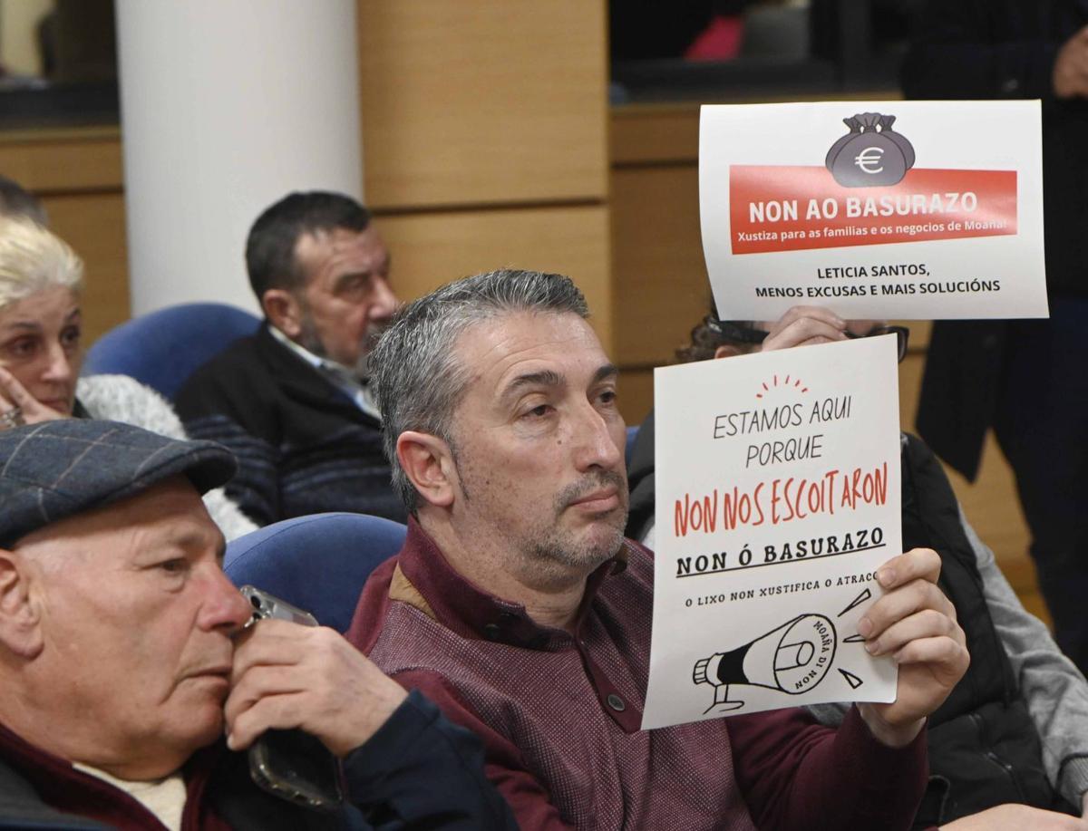 Vecinos con carteles contra el «basurazo» en el pleno de aprobación definitiva de la tasa en Moaña. | PABLO HERNÁNDEZ GAMARRA