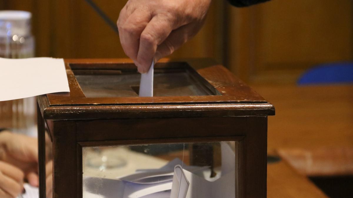 Imatge de detall d'un dels votants dipositant el seu vot a l'urna