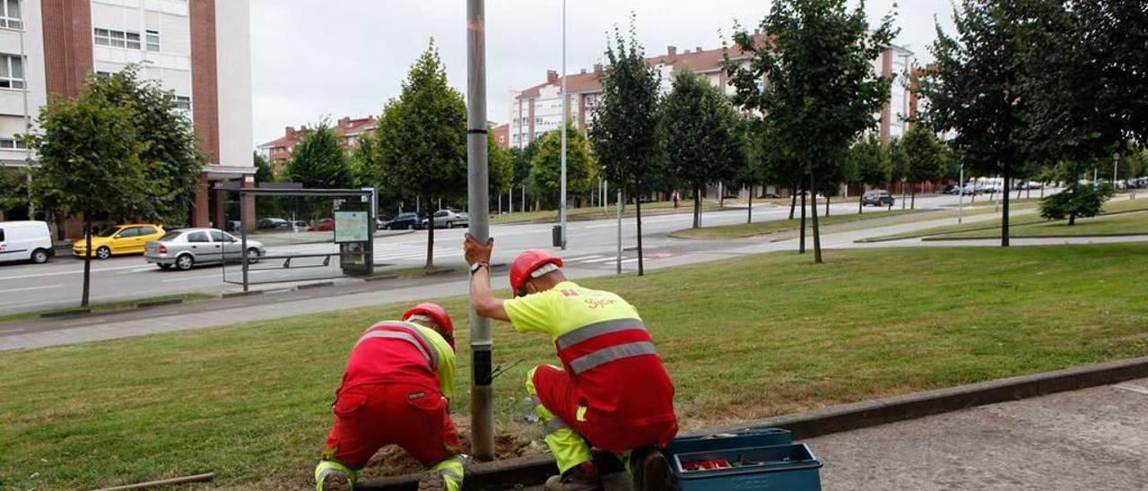 Dos técnicos cambian una farola en la calle de Antonio Machado.