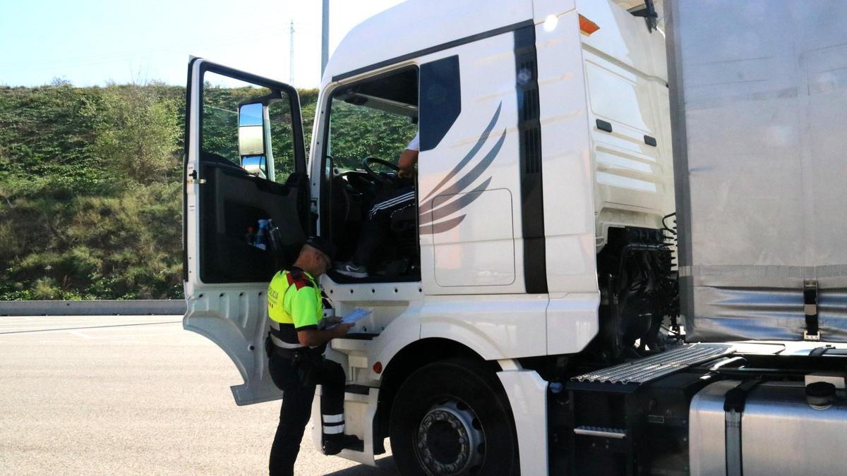 Un agente de los Mossos revisa la documentación de un camión, en la AP7, en Martorell.