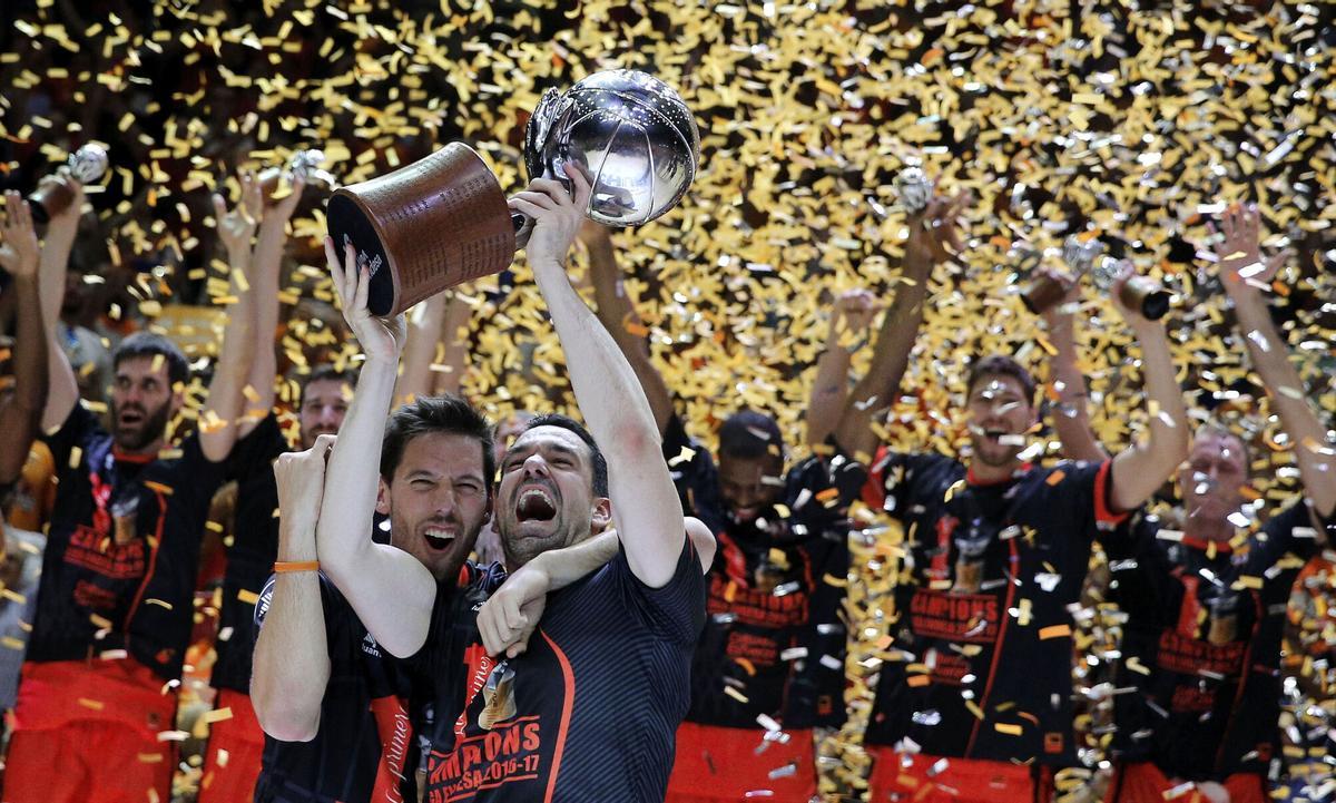 GRA440. VALENCIA, 16/06/2017.- El capitán del Valencia Basket, Rafa Martínez (d), y su compañero, el base belga Sam Van Rossom, levantan la copa de campeones de la Liga ACB tras imponerse en el cuarto partido al Real Madrid esta noche en el pabellón de la Fuente de San Luis de Valencia. EFE/Manuel Bruque