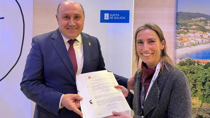 El alcalde, Horacio Gil, recibe de la mano de Ana Muñoz el decreto firmado, ayer, en Fitur. |   // D.P.