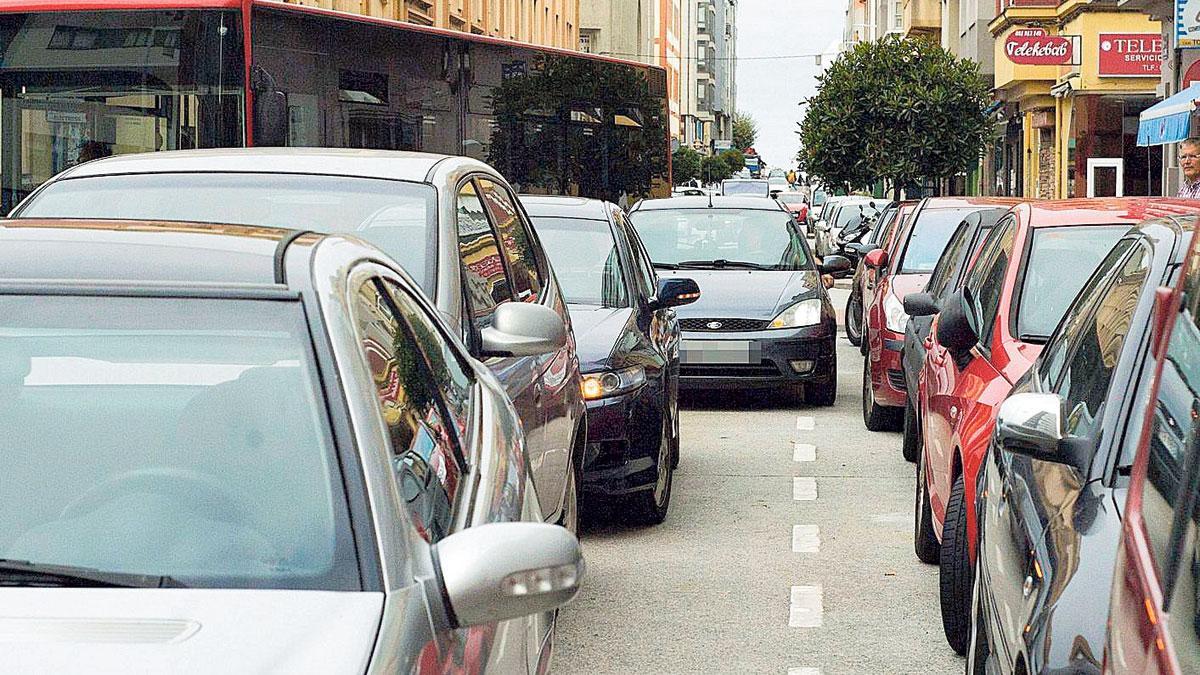 Turismos en doble fila en la calle de la Torre, con un bus maniobrando al fondo. |