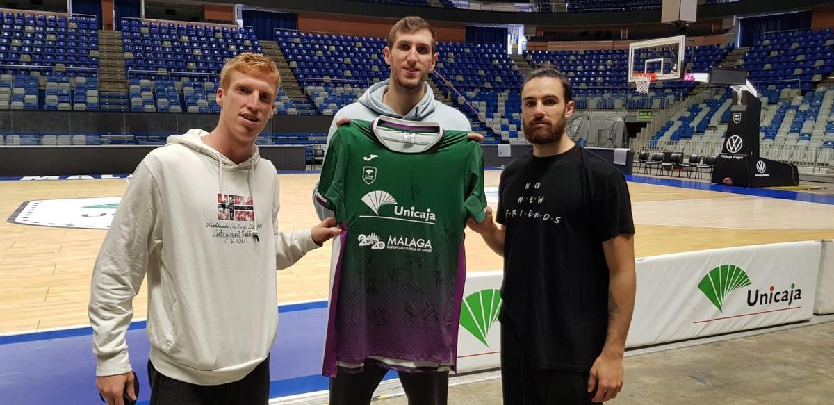 Alberto Díaz, Rubén Guerrero y Francis Alonso con la camiseta del sorteo firmada por la plantilla de Unicaja.