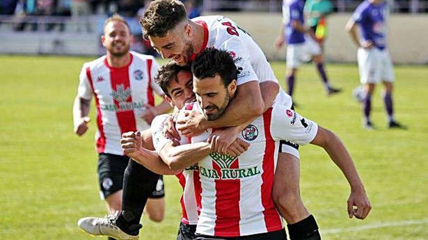 Juanan y David Álvarez abrazan a Murci en la celebrción de un gol.