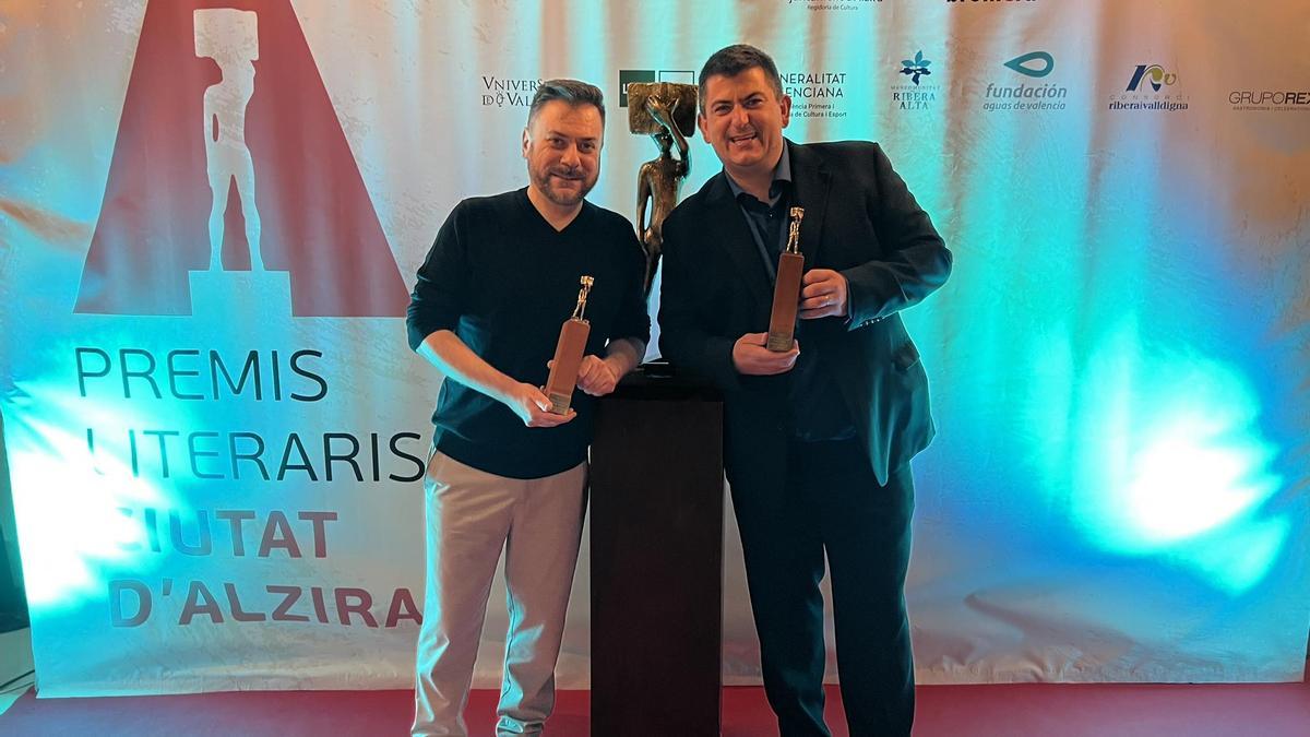 Carles Arbat y Paco Cholbi sostienen el galardón del Premi Literari Ciutat d'Alzira