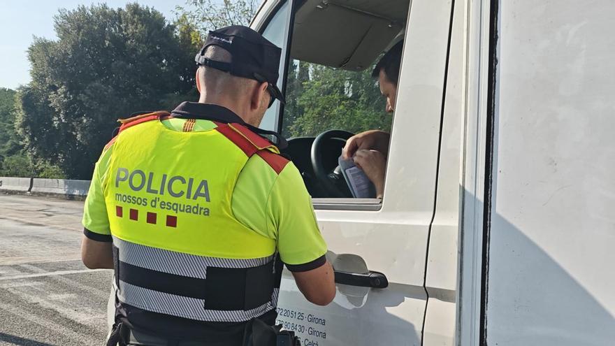 Un mosso comprovant documentació d'un camió, en una imatge d'arxiu.