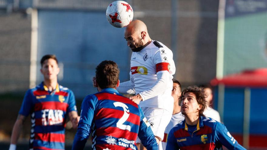 Chechu Flores cabecea el balón ante tres jugadores del Llagostera