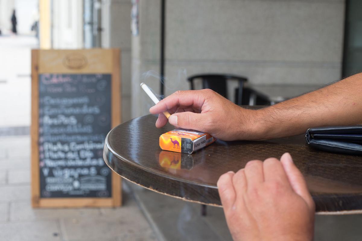 Una persona fumando en una terraza.
