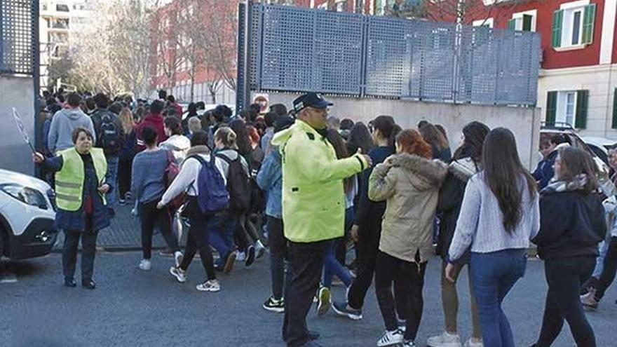 Un policía local supervisa la entrada de alumnos en un centro escolar de Palma.