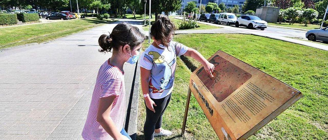 Dos niñas juegan sobre lo que fue parte de la ribera del Gafos. Al fondo, un cartel de los vecinos pide que se destape el río.