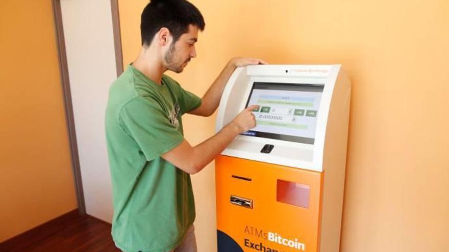 Un jove utilitza el caixer de bitcoins que hi ha a Girona.