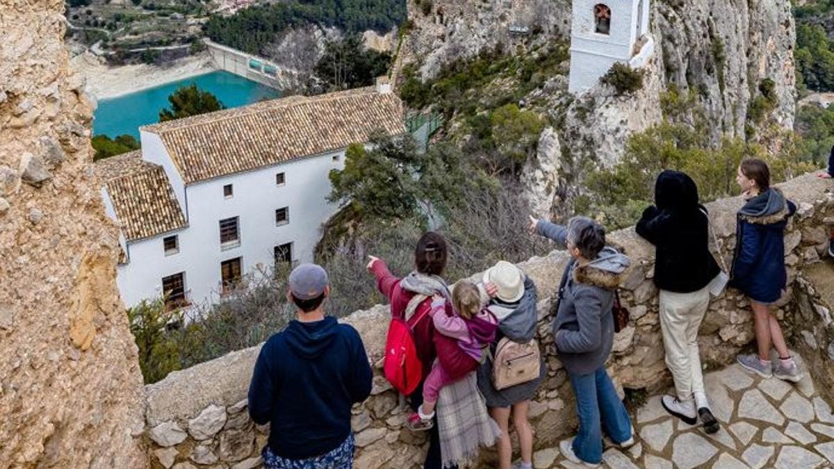 Un grupo de turistas contemplando el casco antiguo de Castell de Guadalest.