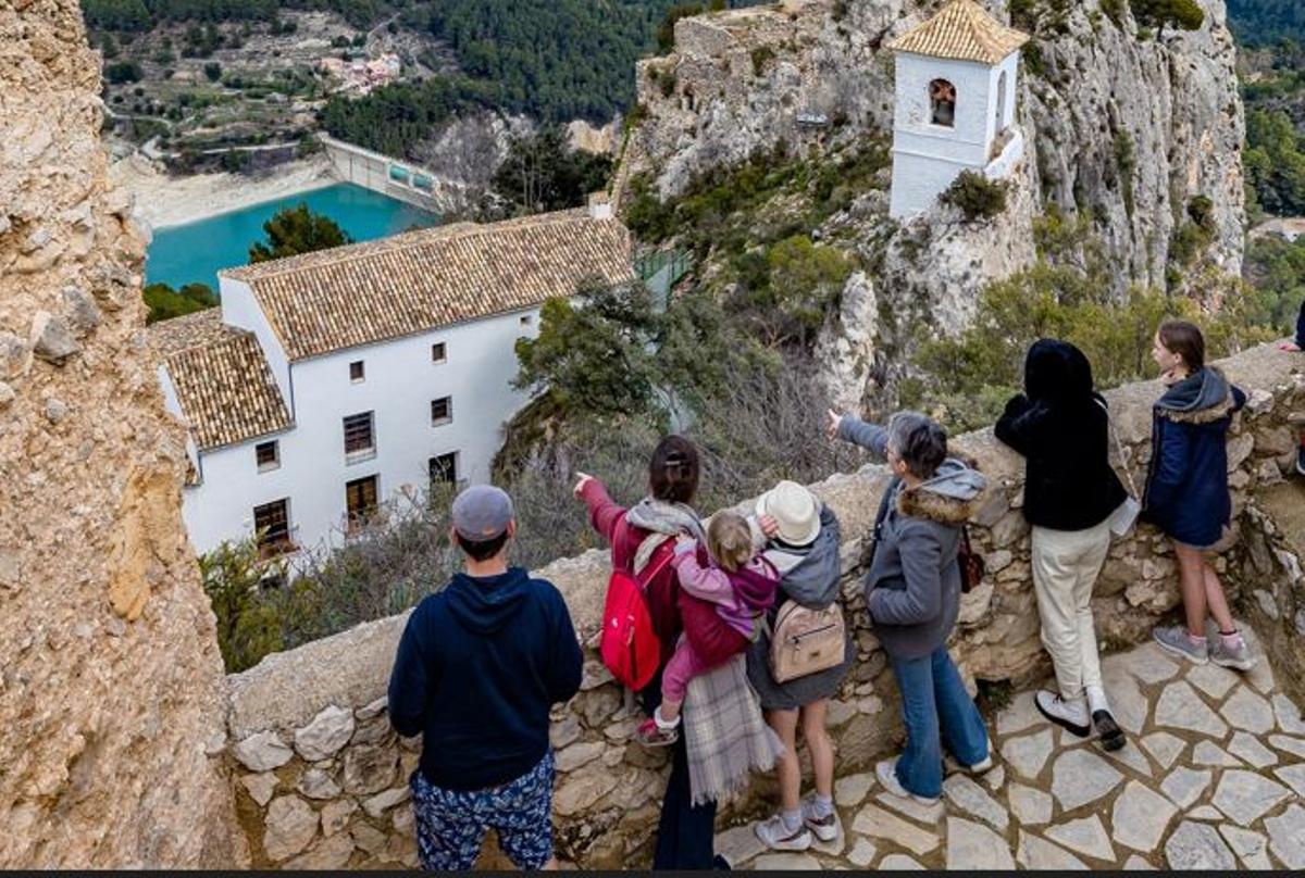 Un grupo de turistas contemplando el casco antiguo de Castell de Guadalest.