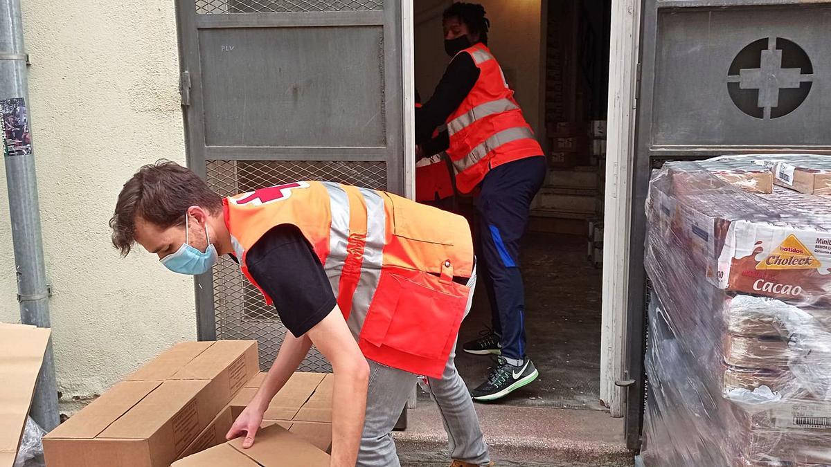 Dos voluntaris de Creu Roja col·laboren amb el banc dels aliments. | DIARI DE GIRONA
