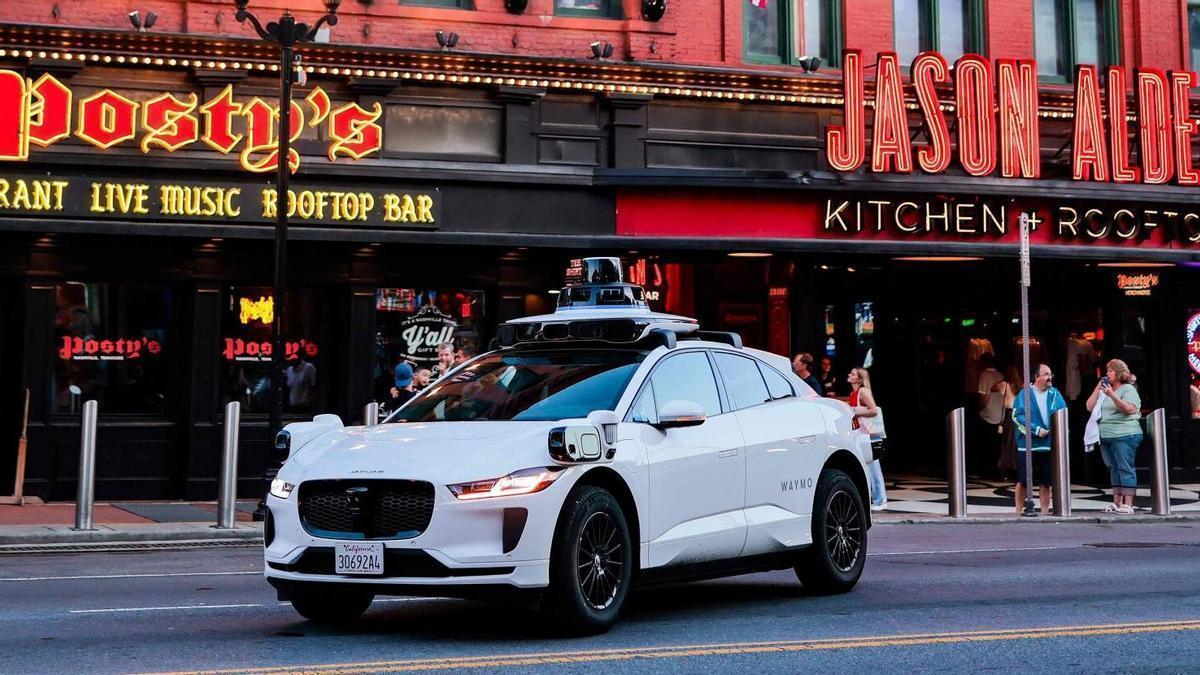 Un vehicle elèctric autònom Waymo Jaguar I-PACE circula per un carrer de la ciutat.