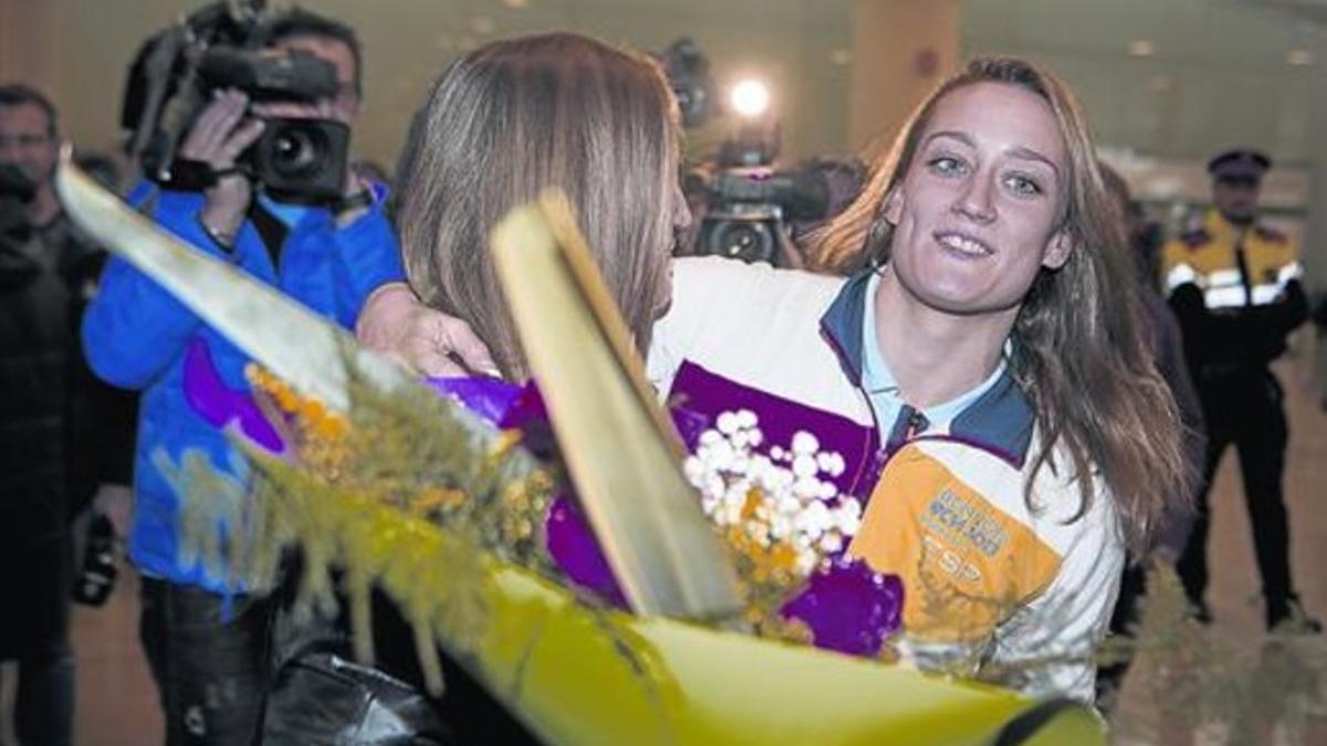 Bienvenida 8 Mireia Belmonte recibe un ramo de flores de manos de su madre, ayer a su llegada al aeropuerto de El Prat.