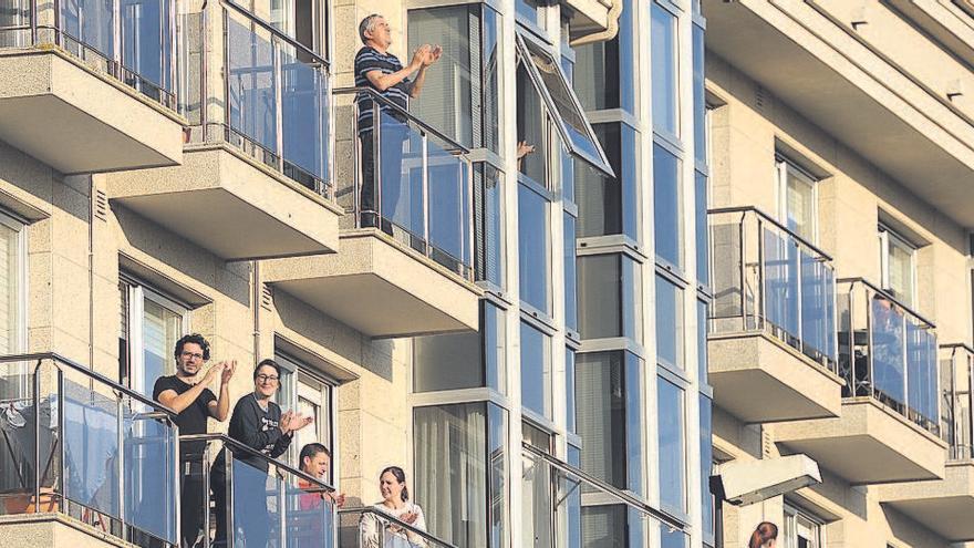 Varias personas asomadas a los balcones durante el confinamiento.