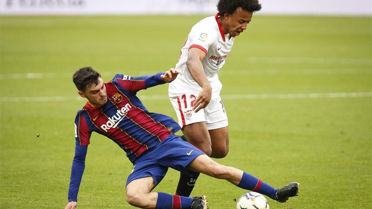 Pedri pelea un balón con el sevillista Koundé