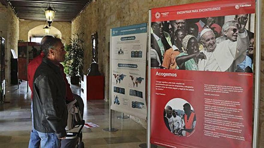 Varias personas visitan la muestra en el claustro del Seminario.