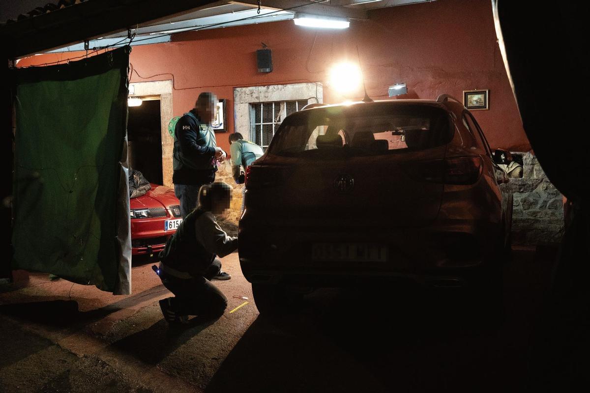 Los agentes de la Policía Judicial de la Guardia Civil toman muestras de uno de los vehículos de la vivienda.