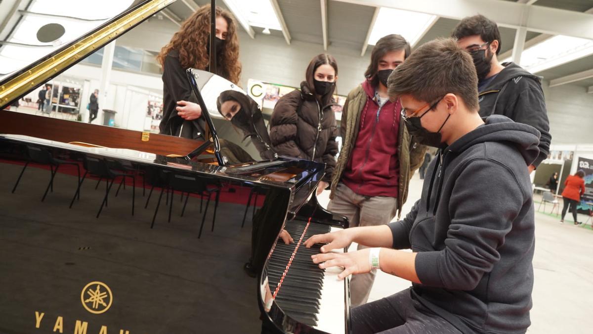 Un joven toca uno de los pianos presentes en la feria