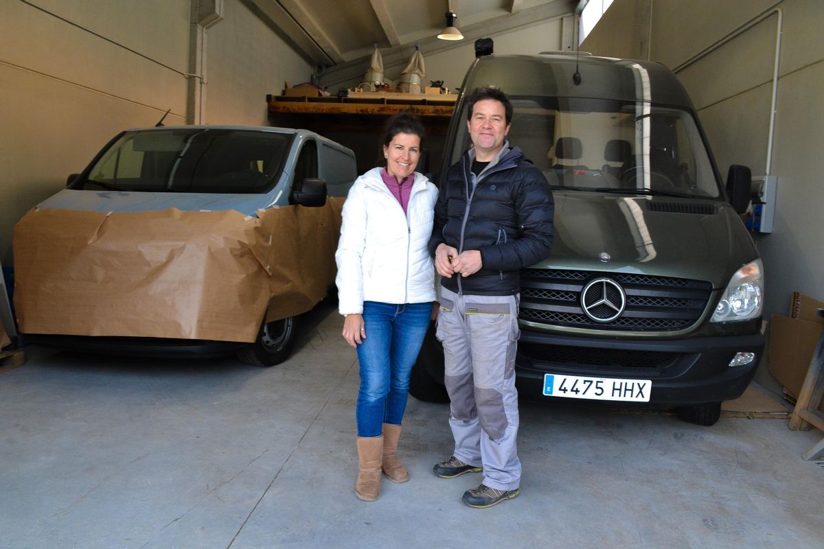 Manuel Fernández y Susana Montefiori posan delante de las dos furgonetas que el primero está camperizando, en el polígono industrial de Bárzana, en Quirós.