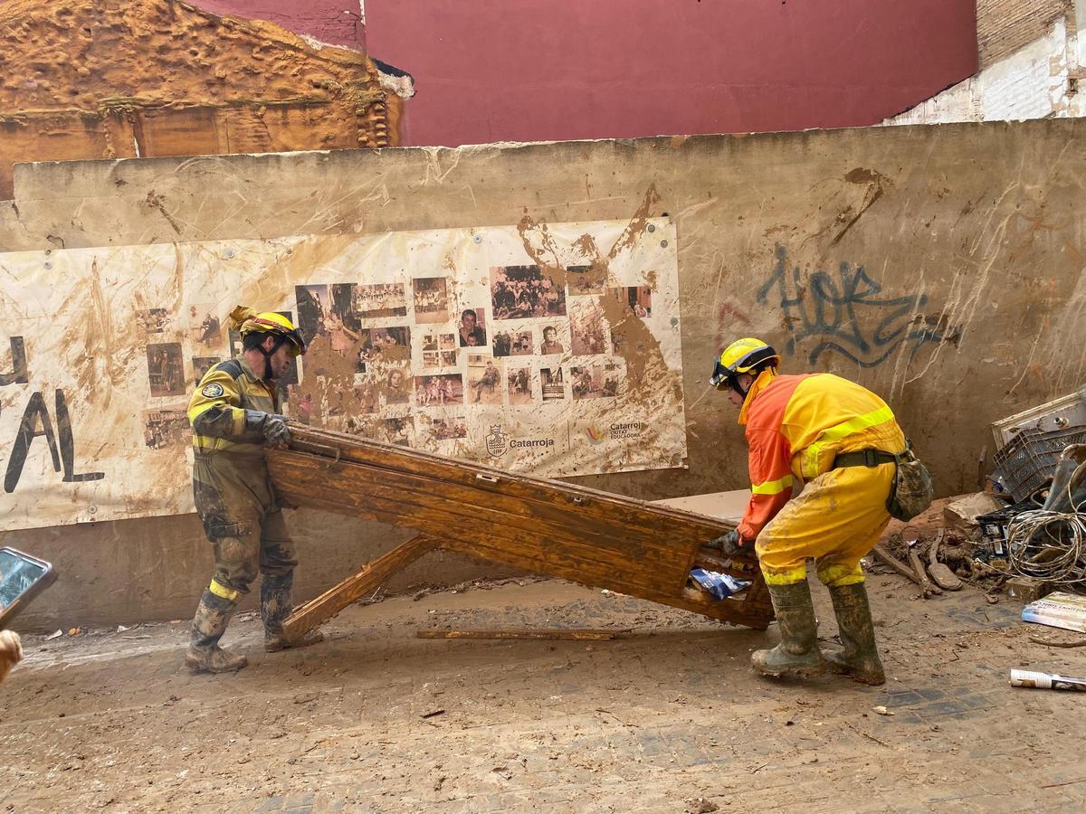 Efectivos de Sarga e Infoar colaboran para retirar una puerta de una calle de Catarroja.