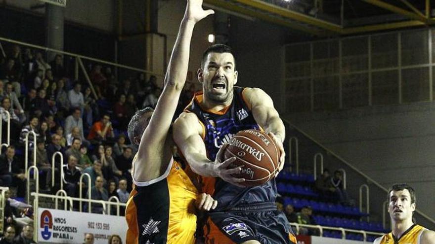 Rafa Martínez penetra a canasta ante la defensa de Román Montáñez .