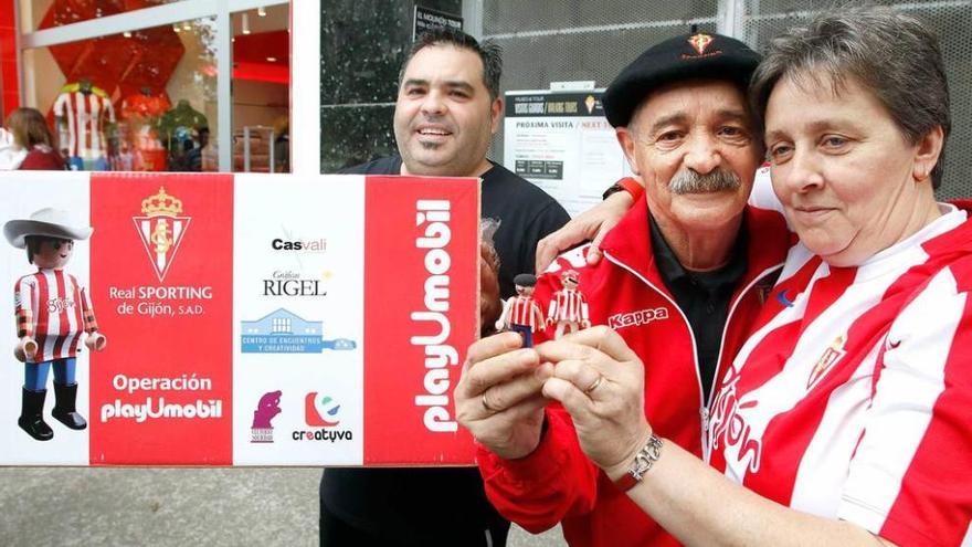 Tomás García, en el centro, con el &quot;playumobil&quot; personalizado con boina que entregó ayer en El Molinón.