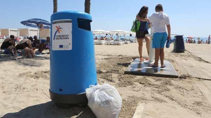 Bolsas de basura junto a una papelera en la playa del Postiguet, ayer, a media mañana.