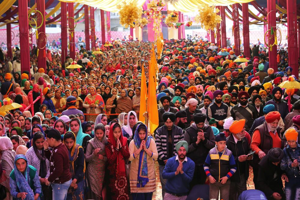 Sikh devotees queue outside a Gurudwara to ...