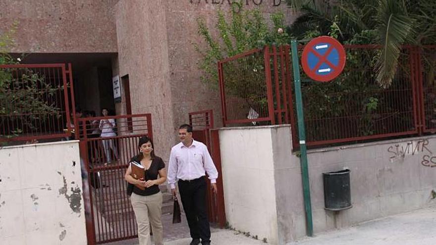 Dos personas abandonan las dependencias del Palacio de Justicia de Alcoy.