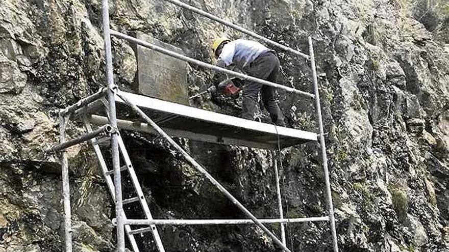 Los operarios retiran la placa franquista.