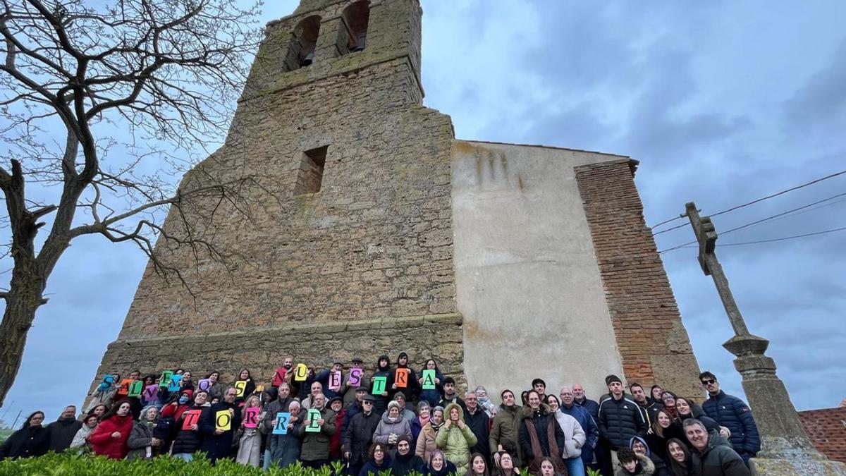 Vecinos de Vega de Villalobos conforman un mural con el lema de la campaña para salvar la torre del templo. | CEDIDA