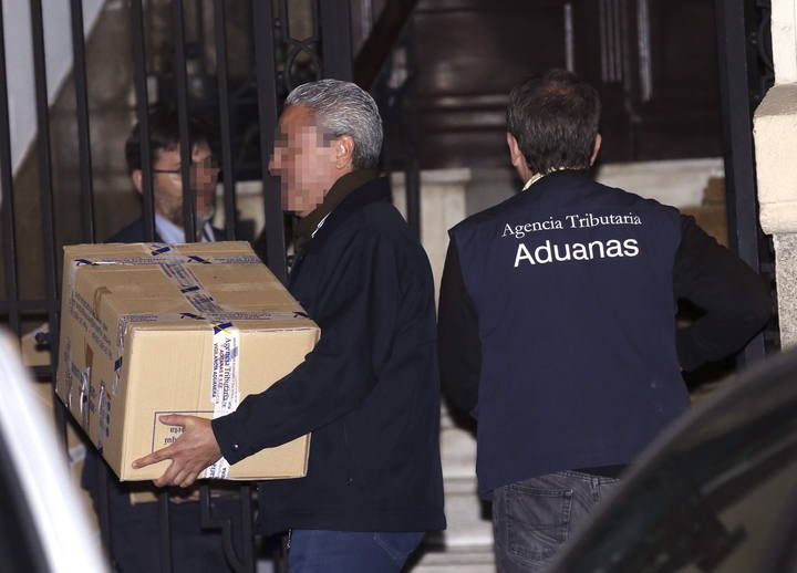 El exvicepresidente del Gobierno Rodrigo Rato (d) abandona su despacho cuatro horas después de que comenzara el registro por parte de los agentes de la Agencia Tributaria y de Aduanas, que han sacado una veintena de cajas con documentación.