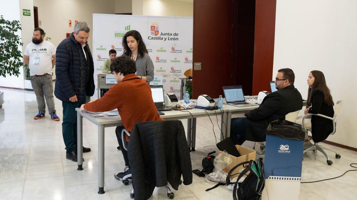 Varios participantes en el foro recogen sus credenciales a la entrada del salón de actos. | Emilio Fraile