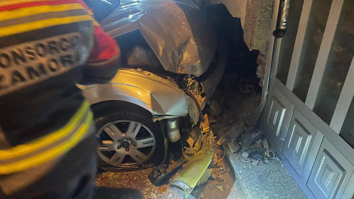 Imagen del coche empotrado en una vivienda de la calle Calleja de Olmillos de Valverde.