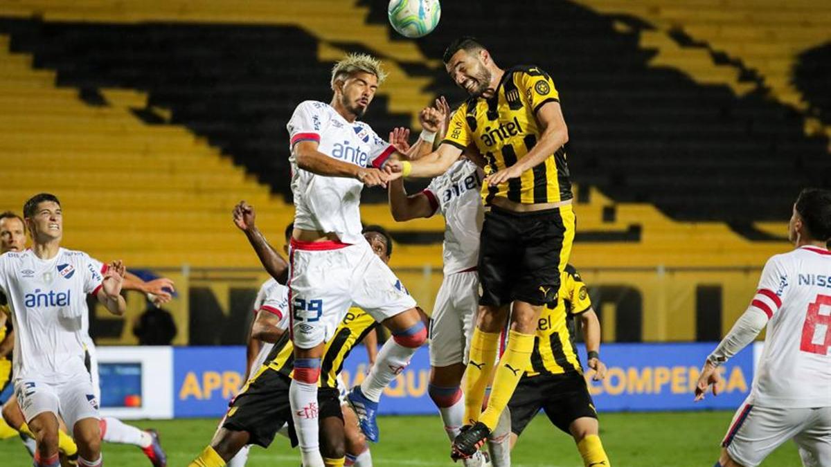 Thiago Vecino (i) del Nacional y Fabricio Formigliano del Peñarol (d) disputan el balón.