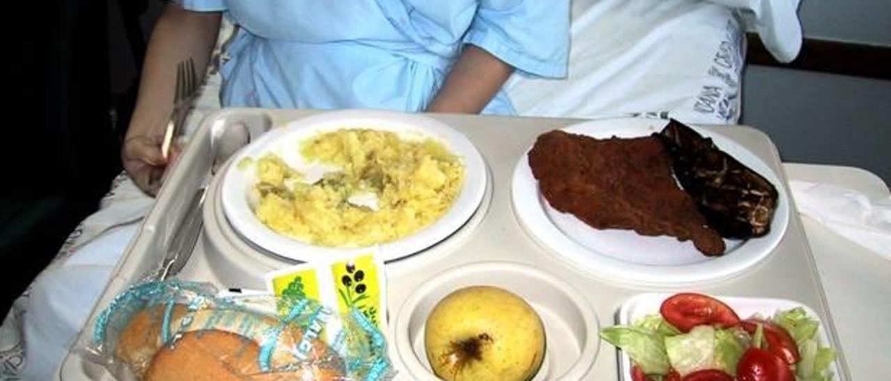 Un paciente ingresado en un hospital valenciano ante una bandeja de comida.