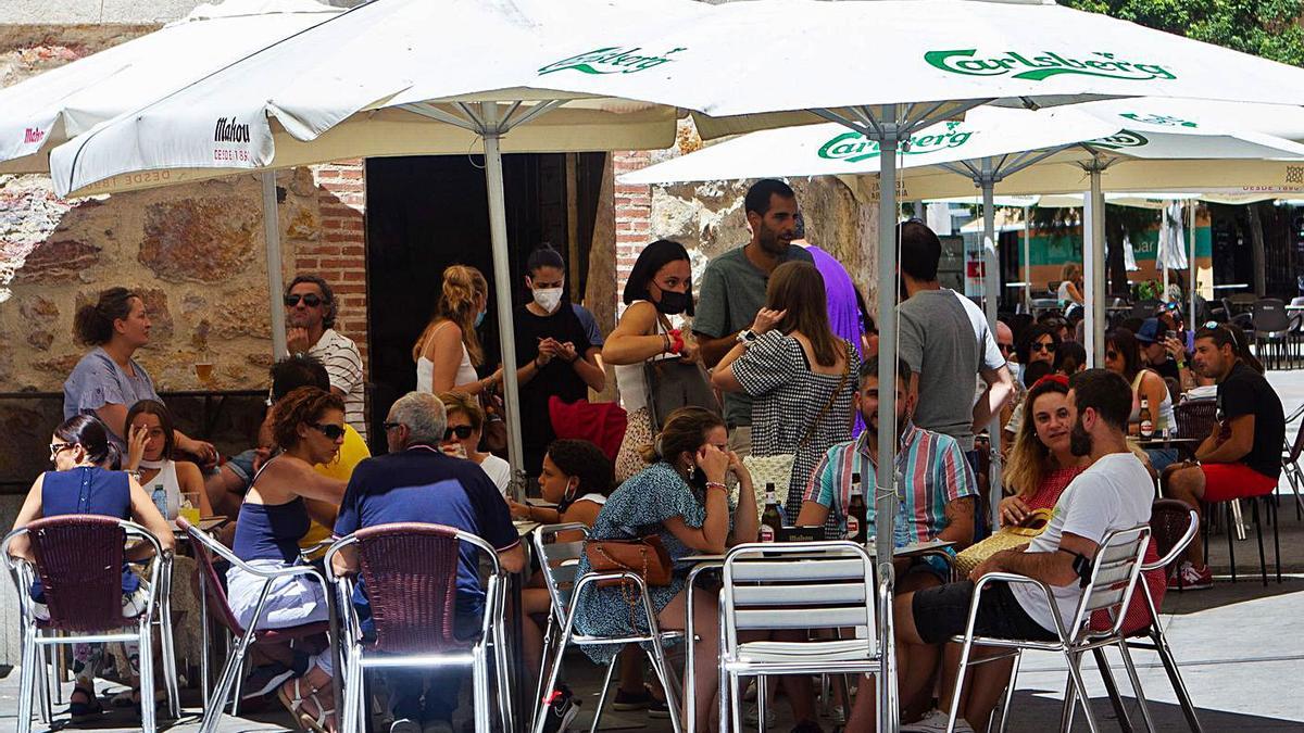 Ciudadanos consumen en una terraza de la capital.