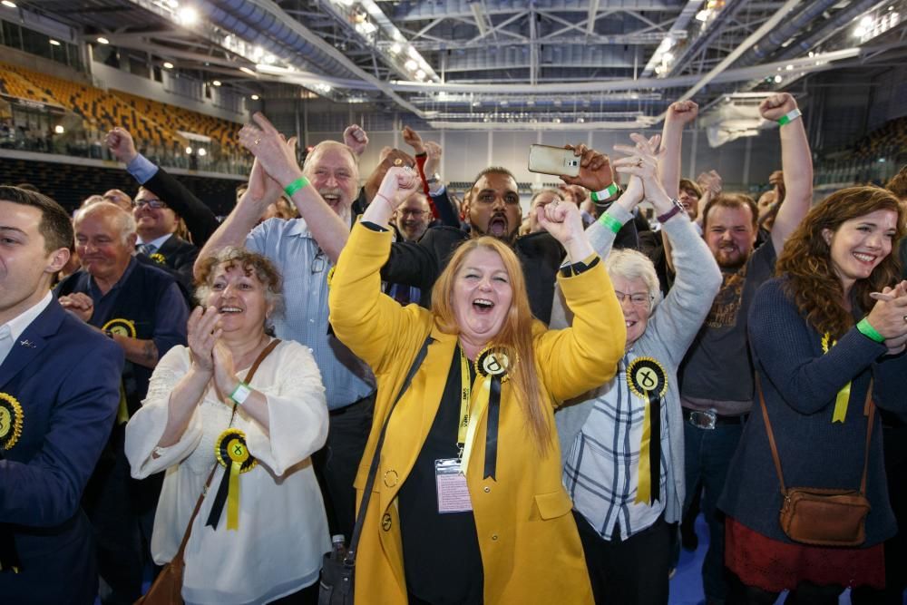 Seguidores del Partido Nacional Escocés celebran después de que su candidato Chris Stephens, ganó el asiento del oeste de Glasgow en la noche de las elecciones.