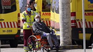 Un sanitario de ambulancia traslada a una persona mayor a la puerta del Hospital 12 de Octubre de Madrid.