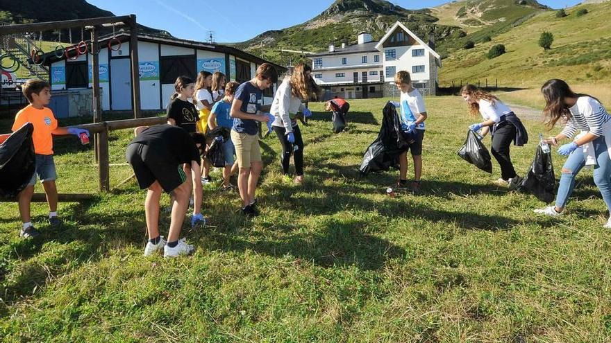 Un grupo de niños recoge basura en la parte baja de Valgrande-Pajares.